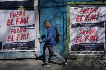 Un hombre pasa frente a carteles de repudio el FMI en una calle de Buenos Aires.