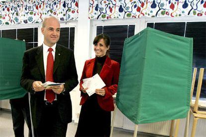 El conservador Fredrik Reinfeldt, acompañado de su esposa Filippa (dcha.), vota en un colegio electoral de Estocolmo.