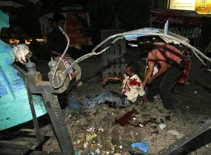 Un herido yace en una acera de la capital india después de registrarse la explosión de una bomba en una papelera cercana