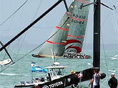 El <i>Nueva Zelanda,</i> ayer, con el mástil roto, y al fondo, el <i>Alinghi.</i>