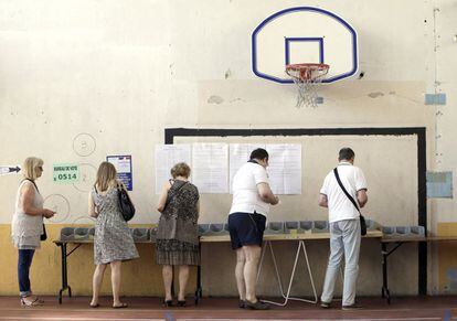Votantes eligen sus papeletas para votar en un centro electoral de Marsella.