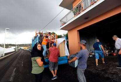 Una familia desalojada carga sus pertenencias en una camioneta en Los Llanos, La Palma.
