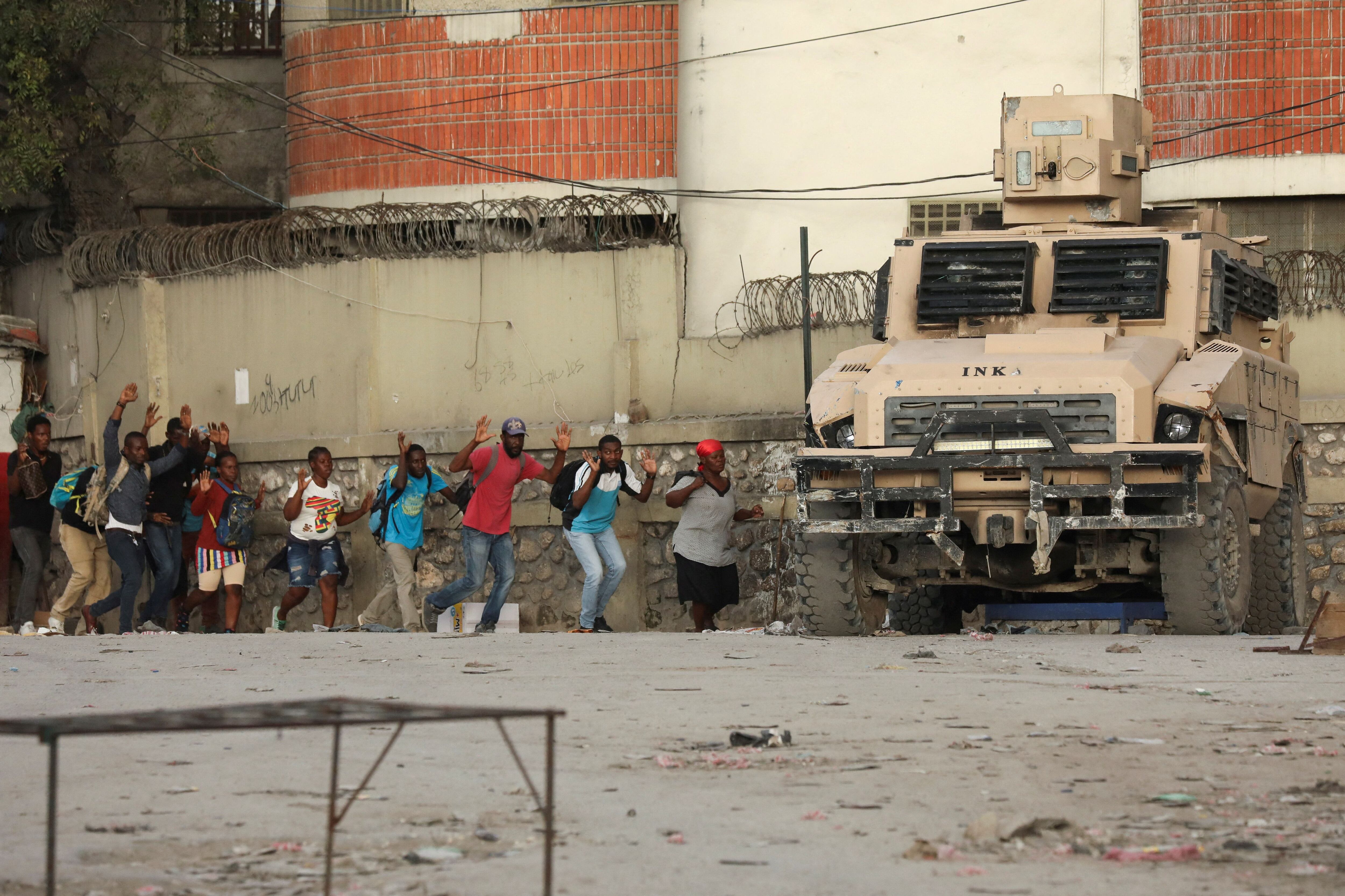 Personas abandonan una zona de Puerto Príncipe donde la policía se enfrenta a pandillas, el 29 de febrero.
