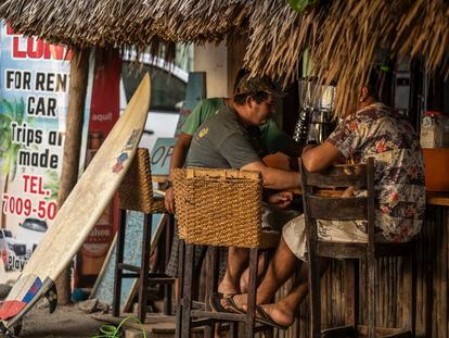 Turistas pasean en la playa El Zonte en El Salvador.