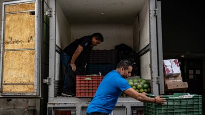 Repartidores de alimentos descargan cajas de verdura en el centro histórico de Ciudad de México.