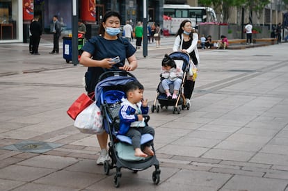 Dos mujeres con sus hijos en una calle de Pekín el 31 de mayo.