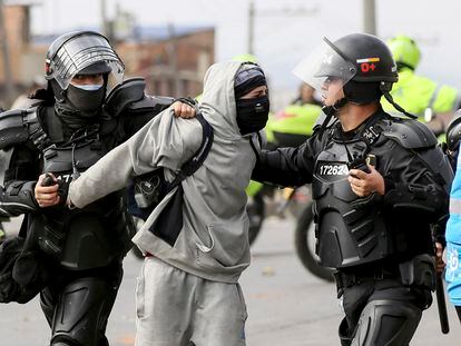 La policía antidisturbios detiene a una persona que participa en una protesta por el aumento en la tarifa de transporte público, en Bogotá, el 6 de enero de 2022.