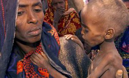 Desnutrición en Somalia. Una mujer sujeta a su hijo, afectado de malnutrición, en brazos en un campo de la ciudad de Danan.