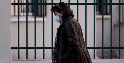 Una mujer con mascarilla camina en una calle de Madrid. 