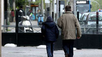 Un niño y un adulto pasean por el centro de Madrid.