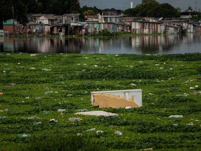 Fotografía tomada el 2 de junio de 2021, que muestra a un refrigerador que flota en las aguas de un arroyo cubierto por gran cantidad de basura, en la región sur de Manaos (Brasil).