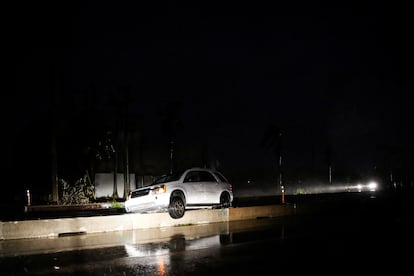 Un auto abandonado y atorado en un muro de contención, durante el paso del huracán, en Fort Myers.