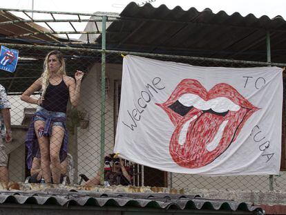 Una cubana mira a los Rolling Stones desde una azotea en La Habana.