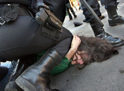 Los <i>mossos</i> reducen a un joven durante los incidentes registrados ayer en la Gran Vía de Barcelona.