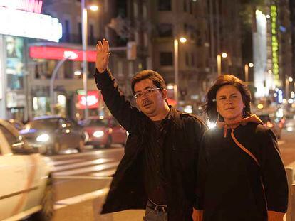 Una pareja de transeúntes intenta detener un taxi en la Gran Vía en la medianoche del pasado viernes.