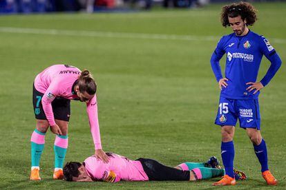 Antoine Griezmann se interesa por el estado de Messi, en el suelo, ante el jugador del Getafe Marc Cucurella.