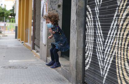 Una niña salta junto al portal de su casa de Sevilla.