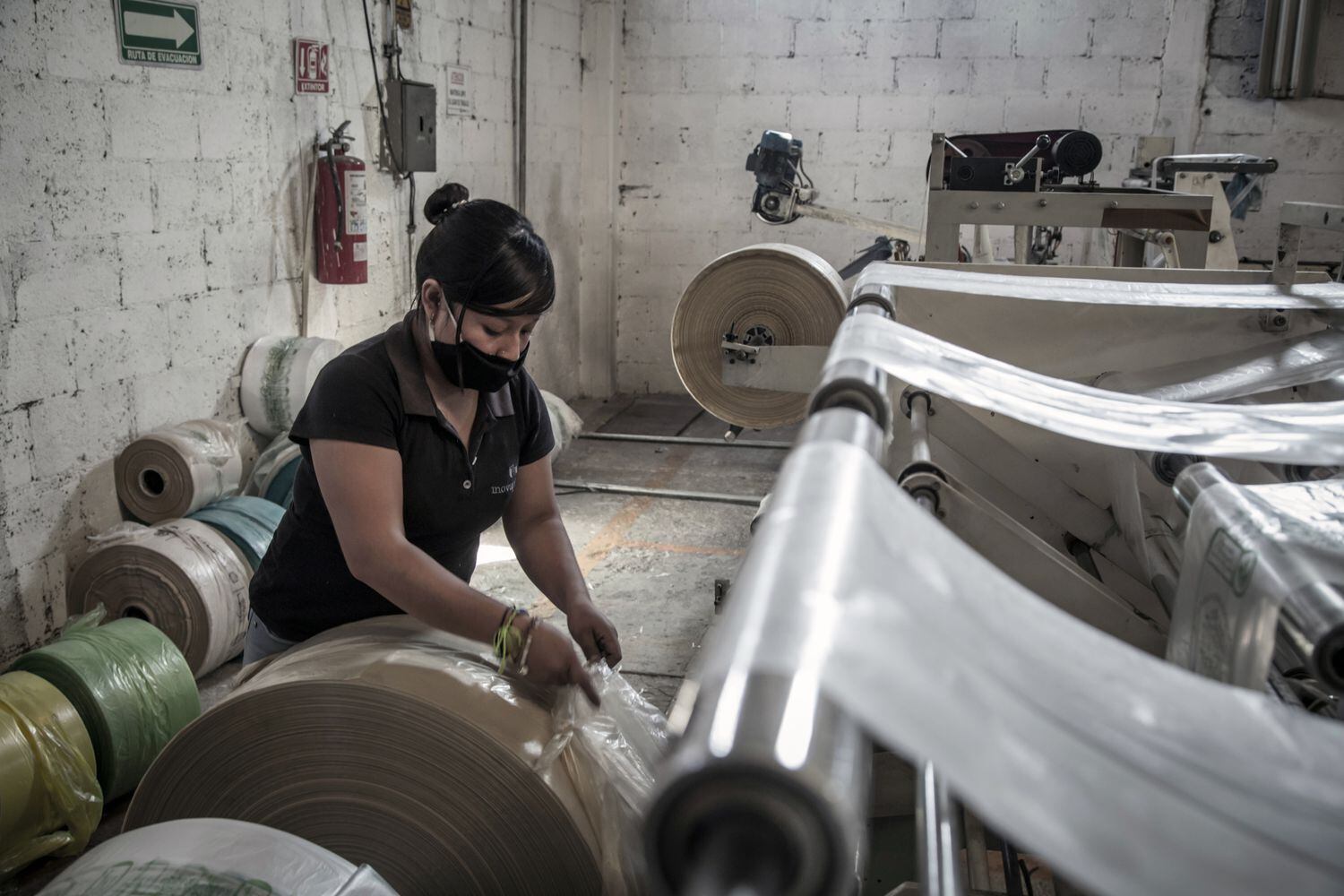 Una trabajadora de Innovaplastix controla el tamaño de las bolsas producidas por una máquina en Toluca, México.