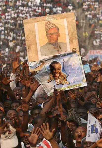 Partidarios del candidato Bemba sostienen una pancarta con su imagen en el cierre de campaña electoral.