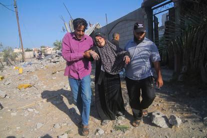 Dos hombres evacúan a una mujer herida tras un ataque israelí en Rafah, en la franja de Gaza, este viernes.