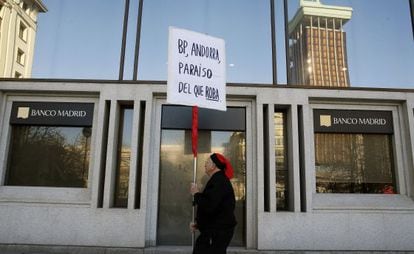 Un hombre protesta ante la sede del Banco Madrid.