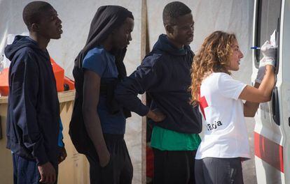 Una voluntaria de Cruz Roja atiende a varios inmigrantes ayer en Algeciras. 