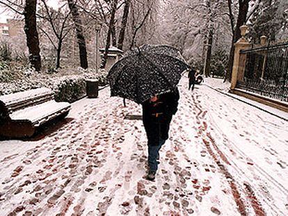 Una persona se protege con un paraguas, en Vitoria, de la fuerte tormenta de nieve que caía entonces.