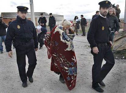 La abuela de los dos niños muertos en el incendio de Villaverde regresa a la chabola escoltada por dos policías.