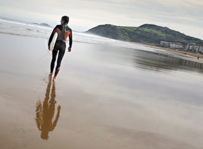 Un surfista en la playa de Zarautz, en cuyo extremo occidental parte el paseo costero que lleva, en algo más de tres kilómetros, a Getaria.