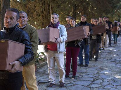 Un grupo de personas traslada restos de víctimas del franquismo exhumadas el pasado año en Cazalla de la Sierra (Sevilla).