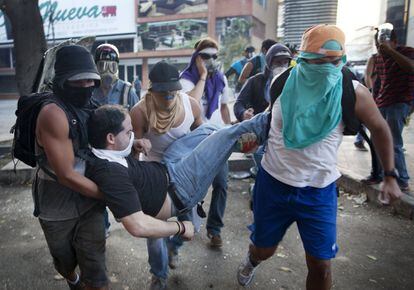 Un grupo de manifestantes trasladan a un herido durante los enfrentamientos con la Guardia Nacional Bolivariana en las protestas contra el Gobierno que duran ya tres semanas