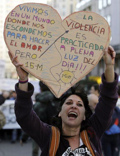 Una manifestante del movimiento 15-M muestra un cartel contra la violencia.