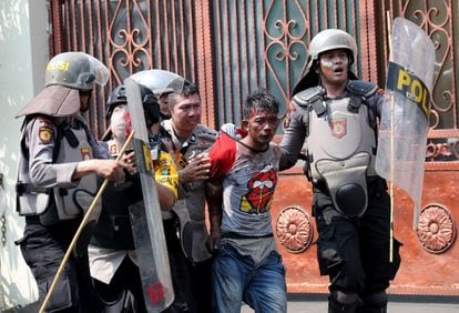 La policía ha detenido a 70 manifestantes, según fuentes de las fuerzas de seguridad, que atribuyeron los enfrentamientos en la capital de Indonesia a "agitadores". Tres policías indonesios arrestan a un manifestante durante las protestas del martes frente al edificio de la Junta de Supervisión de Elecciones (Bawaslu), en Yakarta (Indonesia).