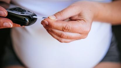 Una mujer embarazada mide su nivel de azúcar.