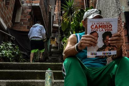 Un hombre lee propaganda política de la coalición de izquierda Pacto Histórico, en el barrio Comuna 13, en Medellín, Colombia, el 27 de mayo de 2022.