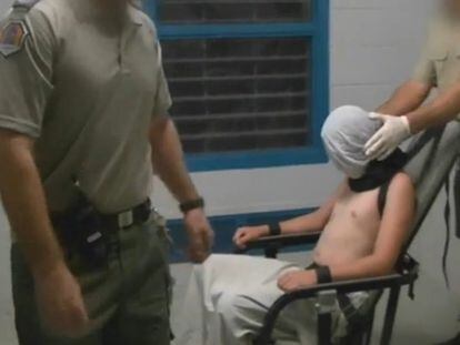 Fotograma del programa de investigación de la televisión australiana Four Corners que muestra a un muchacho con las manos y el cuello atados a una silla y la cabeza cubierta por una capucha en el centro de detención juvenil Don Dale, en Berrimah, Australia.