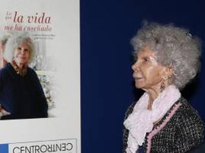 La duquesa de Alba, Cayetana Stuart y Silva, junto a la portada de su nuevo libro, titulado "Lo que la vida me ha enseñado", que ha presentado hoy en Madrid.