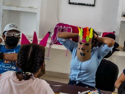 María (derecha), de 16 años, se pone una máscara como parte de una actividad en el Albergue Temporal para Niñas y Adolescentes Migrantes. Separados o No Acompañados en Tapachula, México.