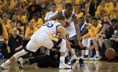 Curry y Barnes, de los Warriors, le roban el balón a Green, de los Spurs.