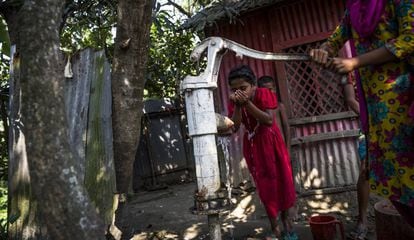 Una niña bebe de un pozo contaminado con arsénico en Totar Bagh, Bangladesh.