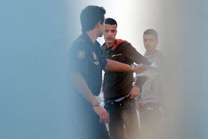 Un policía custodiaba ayer a dos inmigrantes en el CIE de El Matorral, en Fuerteventura.