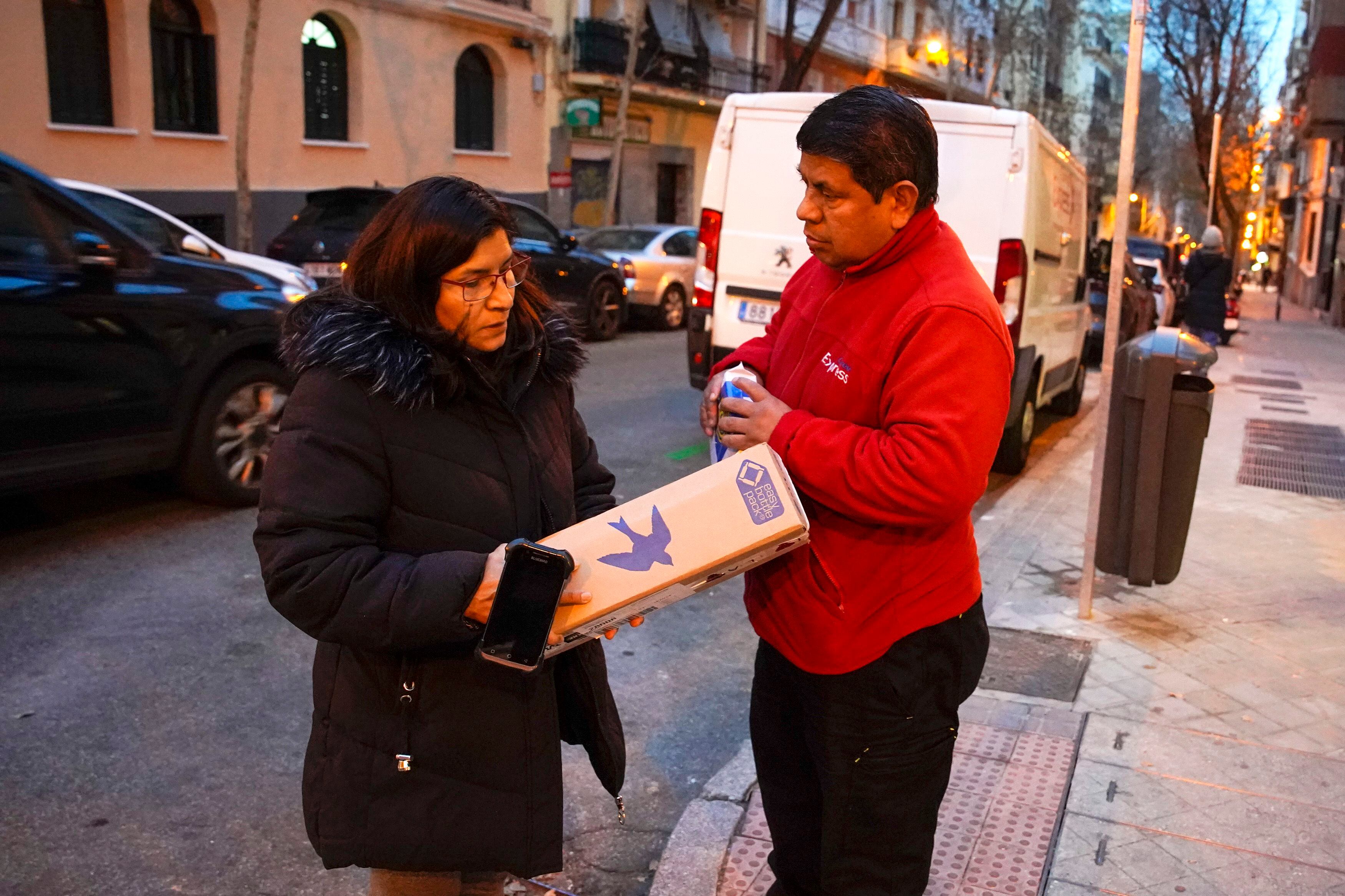 El repartidor Amado López y su mujer Mónica se reparten paquetes durante el trabajo en Madrid.