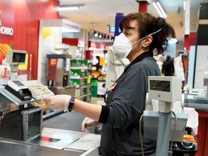 Cajera de un supermercado provista con elementos de protección frentre al coronavirus. 