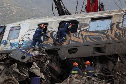 Bomberos buscan víctimas entre los restos de uno de los vagones siniestrados.  El accidente ocurrió cuando un convoy de pasajeros que cubría la ruta entre Atenas y Tesalónica chocó con uno de mercancías.