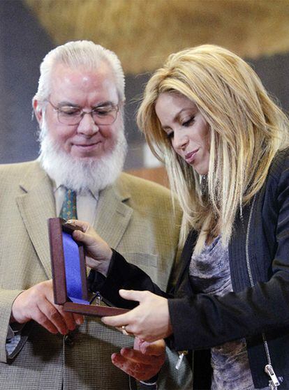 La cantante Shakira mira la medalla que le ha otorgado la Organización Internacional del Trabajo en presencia del director general de la institución, Juan Somavia.