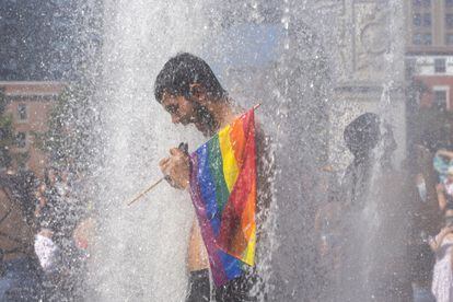 Un homme se rafraîchit dans une fontaine lors de la marche de libération queer de New York le dimanche 26 juin.