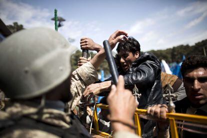 Un soldado del Ejército Nacional Afgano retiene a un seguidor de Abdullah Abdullah que quería saltar la valla para pasar al estadio en el que se celebraba un acto electoral.