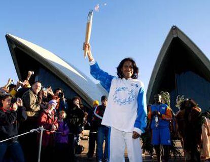 Cathy Freeman con la antorcha olímpica delante de la Ópera de Sidney.