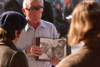Martin Scorsese muestra una de las ilustraciones del libro de Brian Selznick a Asa Butterfield (izquierda) y Chloë Grace Moertz en el rodaje del filme.