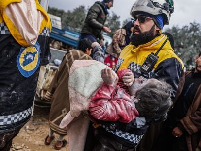 Miembros de los Cascos Blancos sirios transportaban el lunes a una niña herida tras el terremoto.